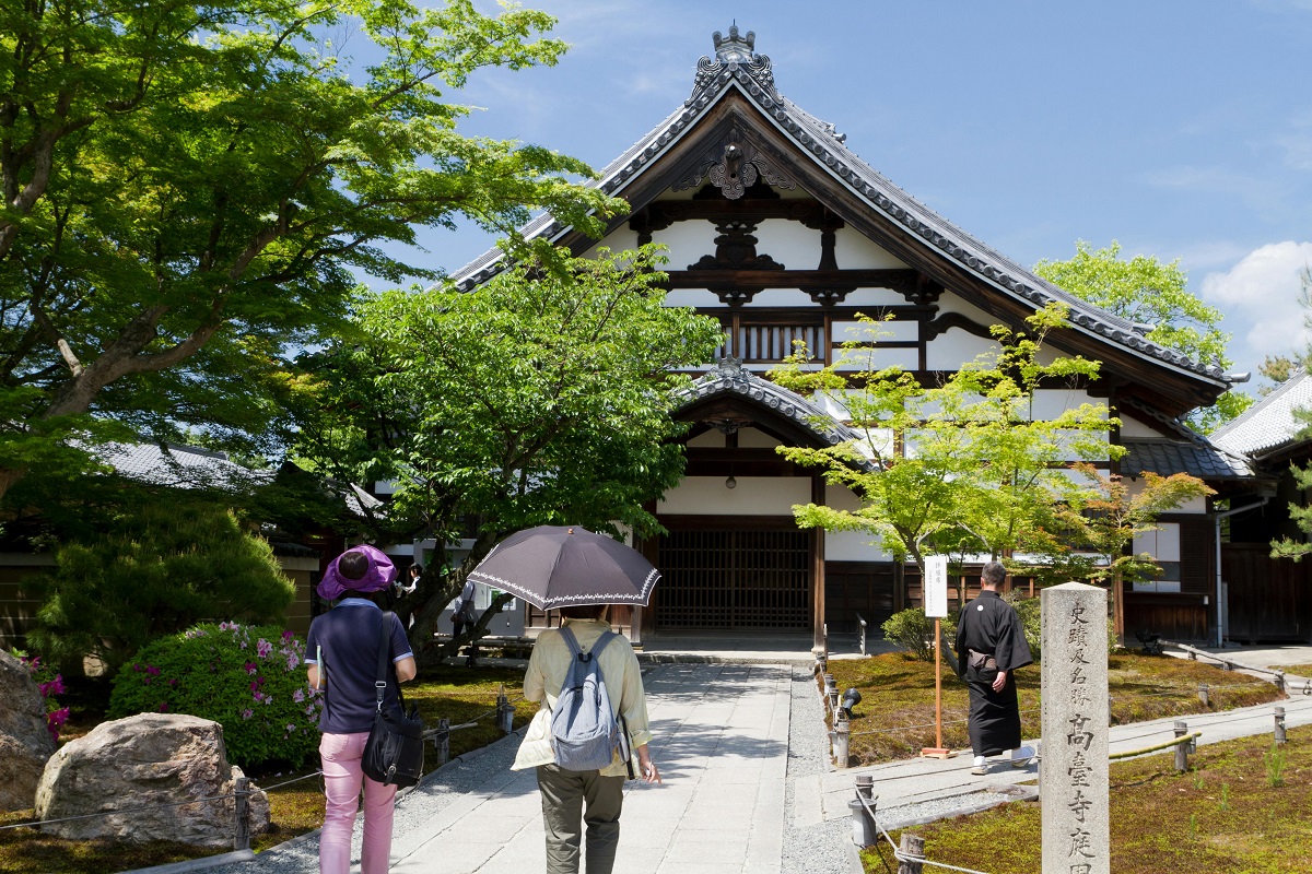 tourist using an umbrella at a temple in Kyoto